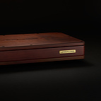 The <b>BlackGround 6x Power Base</b> features a lacquered wooden enclosure and hand finished brass placard on its front.