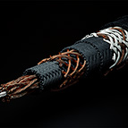 Pictured above is the C-MARC™ Triaxial cable, Bulk. It is highly flexible and features 192 individually enameled, 0.125mm diameter copper conductors around a 100% cotton core. The copper structure is then overbraided with 100% natural, mercerized cotton fiber, then another braid of 192 enameled copper wires. Above that are two layers of mercerized cotton fiber braids, then a third layer of copper (96 strands) and cotton. Finally, two outer cotton layers cover the cable. There are no plastics throughout. The total conductive cross section of this wire is 2 x 2.3mm^2 plus 0.864mm^2 for out outer braid. We use this wire for our C-MARC™ XLR interconnects and Power Cable. End prepping carried out by LessLoss is not available for this product.